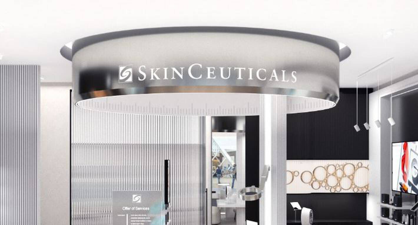 Un interieur de magasin moderne avec une grande signalisation ronde de SkinCeuticals au plafond.