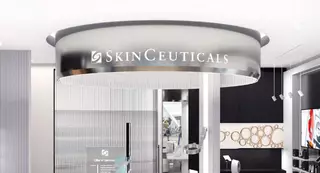 Een moderne salon met een opvallend zilverkleurig bord met de naam "SkinCeuticals" bovenaan.