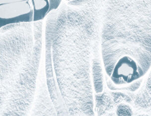 Abstract close-up of translucent ice, showcasing intricate textures and patterns with a cool blue tint.