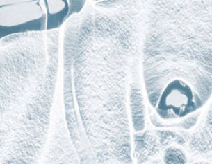 Abstract close-up of translucent ice, showcasing intricate textures and patterns with a cool blue tint.