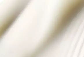 Tissu blanc drape, creant des ondulations douces et elegantes, evoquant legerete et fluidite.