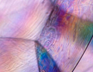 Texture coloree et irisee d&aposune surface, affichant des motifs fluides dans des teintes pastel vibrantes.