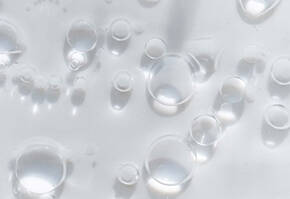Diverse waterdruppels en luchtbellen op een heldere, doorzichtige achtergrond.