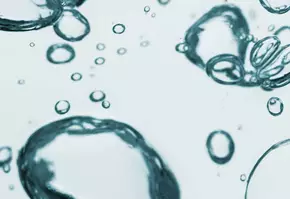 Bubbles d'eau flottant dans un liquide clair, creant un effet de texture apaisant et dynamique.