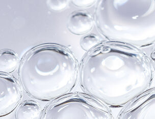 Close-up of clear bubbles on a light background, creating a textured and abstract appearance.