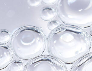 Close-up of clear bubbles on a light background, creating a textured and abstract appearance.