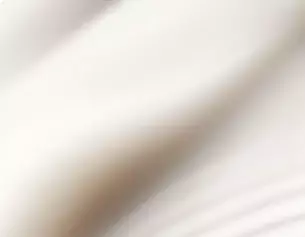 Vervaagd beeld van een lichte, zachte stof die een gevoel van elegantie en beweging uitstraalt.