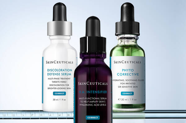 Trois flacons de serums pour la peau SkinCeuticals sont places cote a cote : Discoloration Defense Serum, HA Intensifier Multi-Glycan et Phyto Corrective.