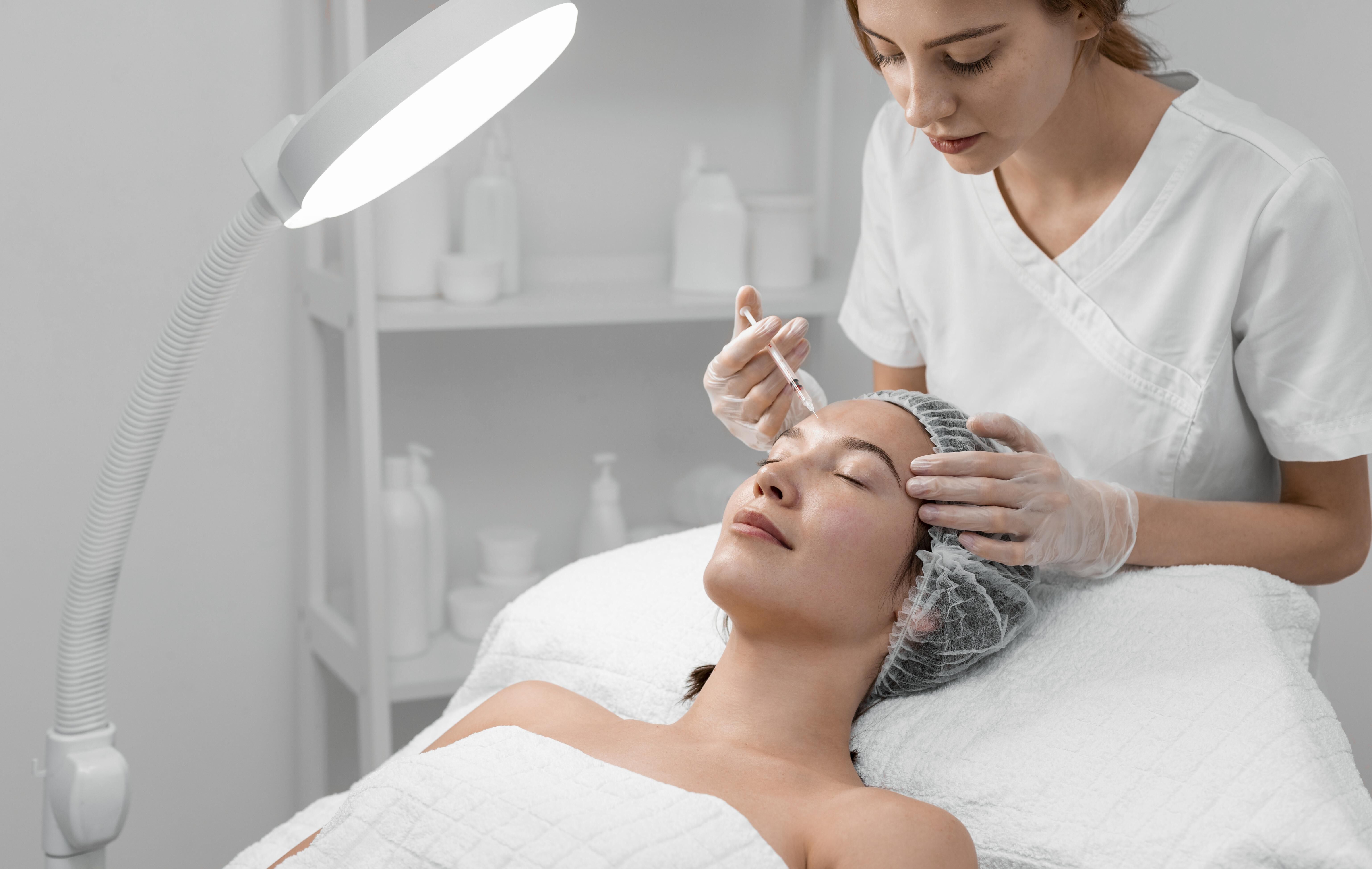 Une femme recoit un soin de la part d'une estheticienne dans un environnement spa moderne.
