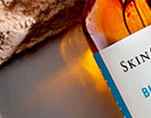 Flesje SkinCeuticals Blemish + Age Defense serum ligt op een lichte, ondergrondse textuur.