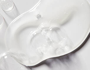 A close-up of a translucent gel, showing its smooth texture and reflective surface on a white background.